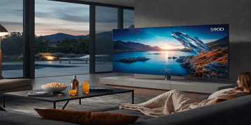 Samsung S90D OLED TV displayed in a modern living room setting showing vibrant picture quality.