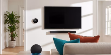 A modern living room with an Amazon Echo smart speaker on an end table and a Google Nest smart thermostat mounted on the wall.