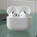 AirPods 4 hardware data showing the open charging case on a glass countertop without silicone tips.