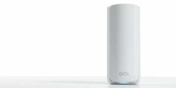 White Netgear Orbi mesh router unit standing on a white surface against a bright white studio background.